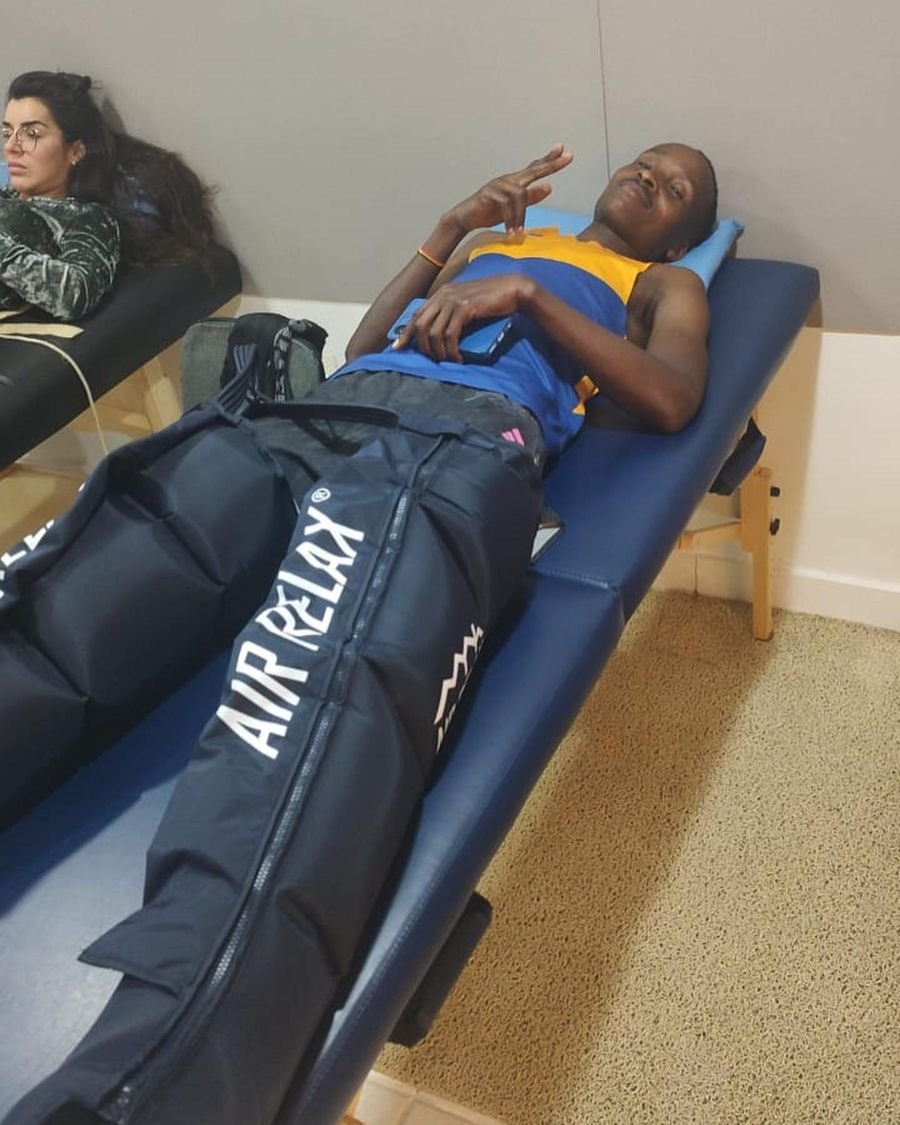 Atleta deitado com botas de compressão de Recovery na clínica